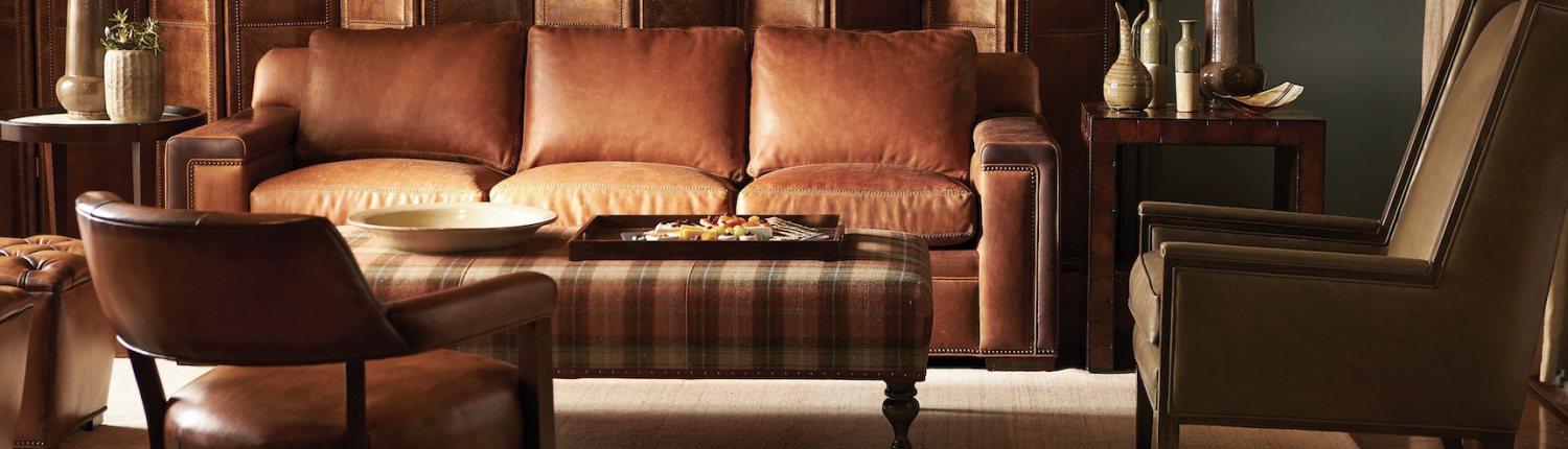 Traditional Minnesota living room with a rich leather sofa and a plaid ottoman.