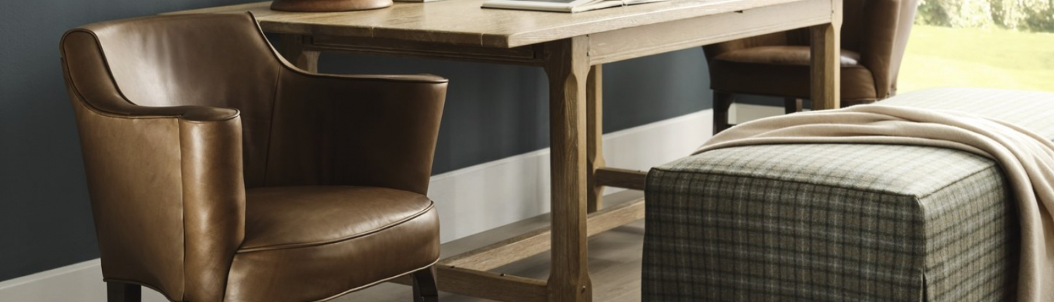 Leather and wood arm chair with a skirted plaid ottoman at a desk, find items alike at Traditions in Minneapolis.