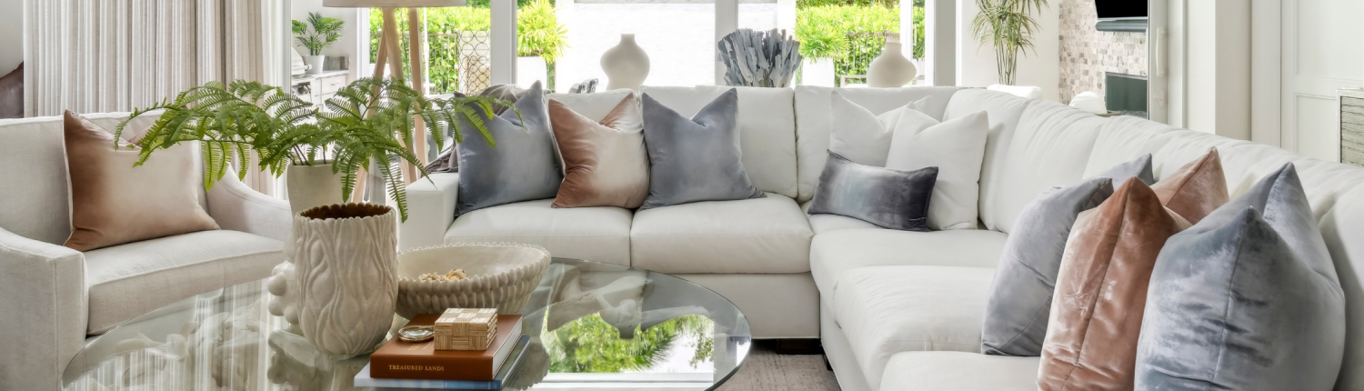 Contemporary great room in Naples, Florida featuring a white sectional, soft neutral palette, and layered textures by Traditions.