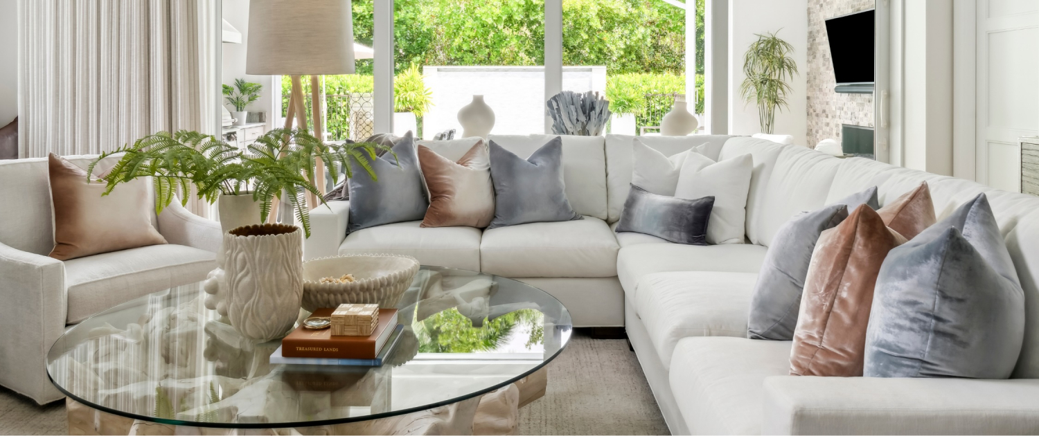 Contemporary great room in Naples, Florida featuring a white sectional, soft neutral palette, and layered textures by Traditions.