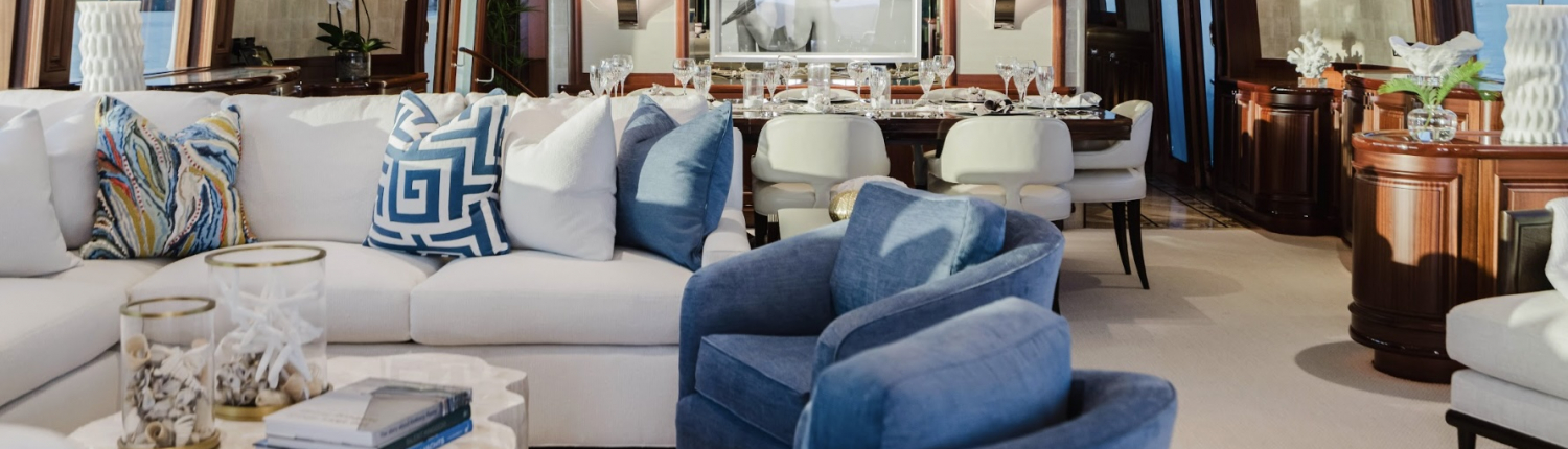 Furnished yacht living room in Naples, Florida with blue and white nautical-inspired sofas and décor.