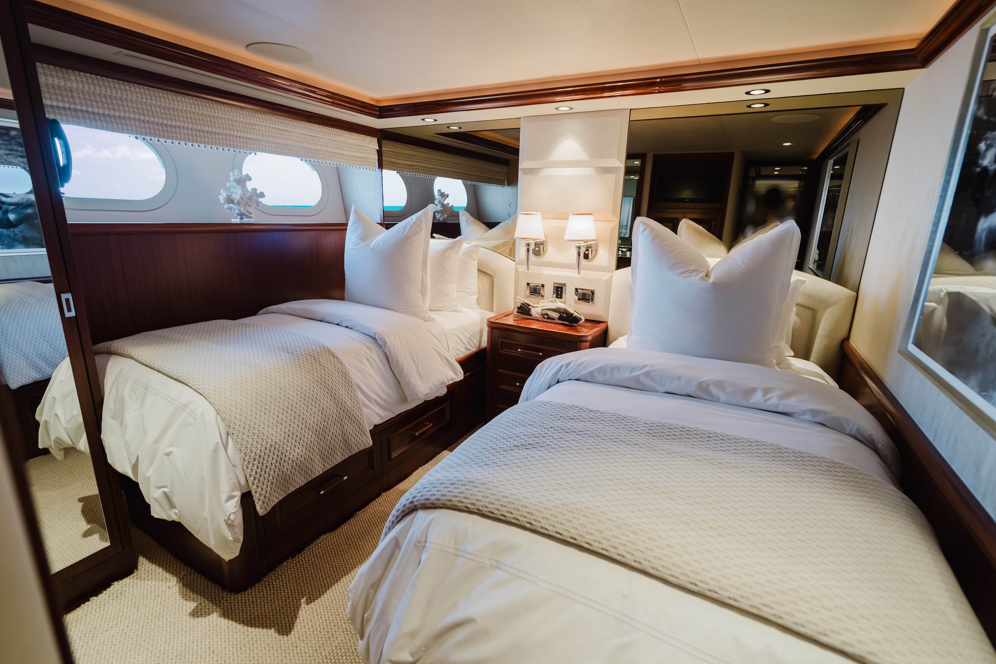 Naples yacht interior design showcasing a twin stateroom with tailored storage and refined finishes