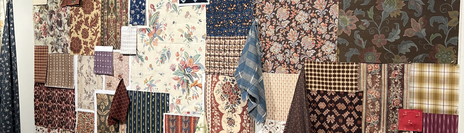 Showroom display at High Point Market Spring 2026 featuring warm brown tones, carved wood furniture, and mixed fabric upholstery